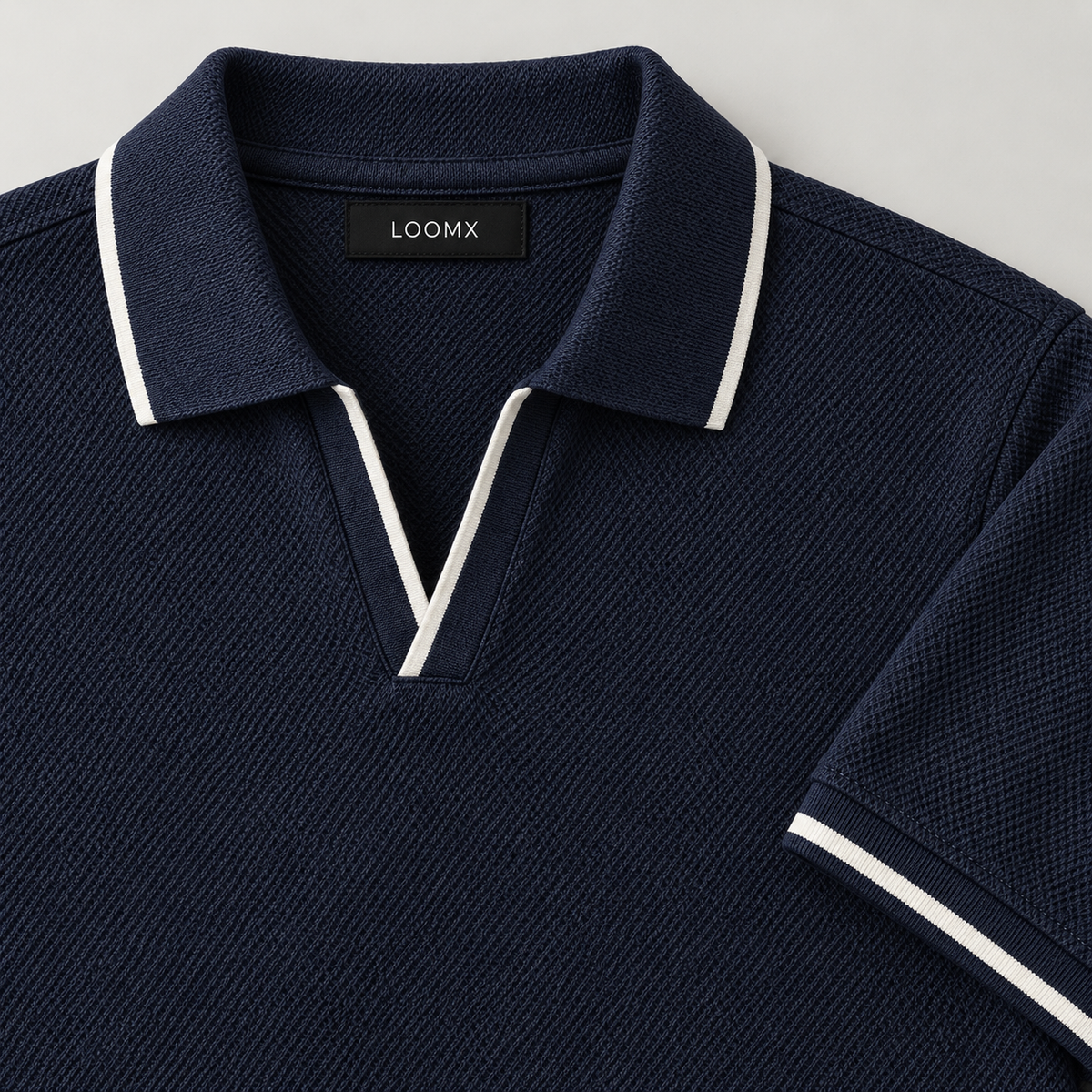 Navy piqué polo open V neckline and white contrast tipping — detail